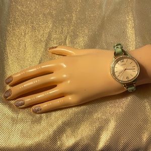 Fossil rose gold with mint green leather band.